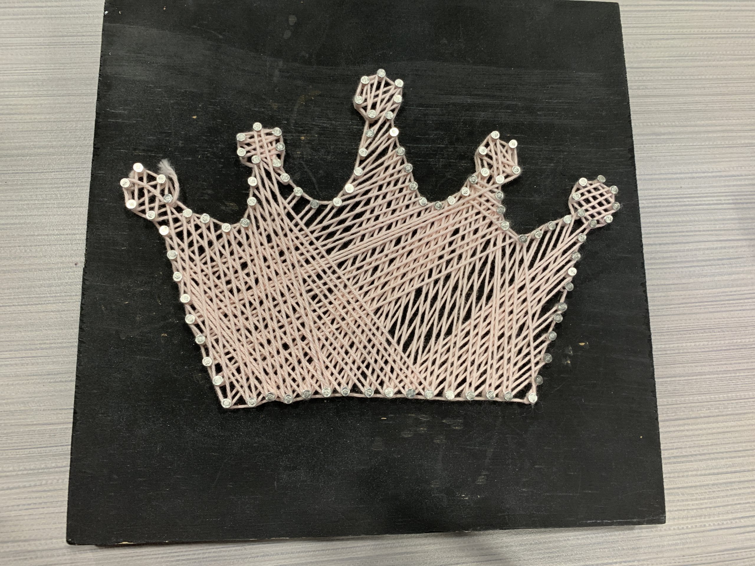 Crown made of string on a board