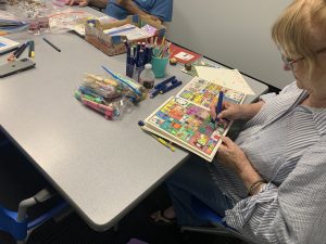 Coloring club members work on their creations