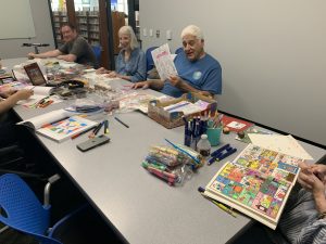 Coloring club members work on their creations