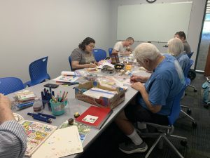 Coloring club members work on their creations