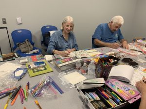 Coloring club members work on their creations