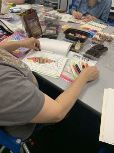 Coloring club members work on their creations